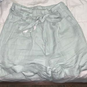 Light wash green shorts.